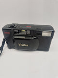 1. Vivitar D535 sett forfra med objektivdeksel og innebygd blits.
