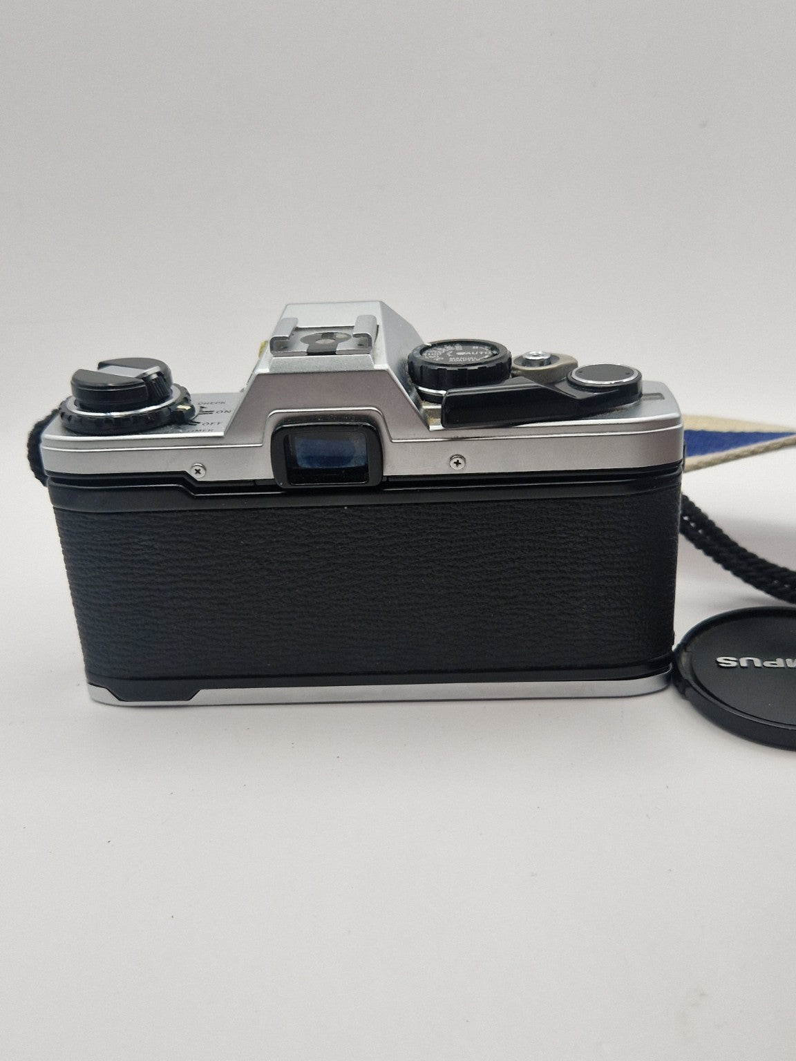 Bakside av Olympus OM-10 med søker og original kamerarem.