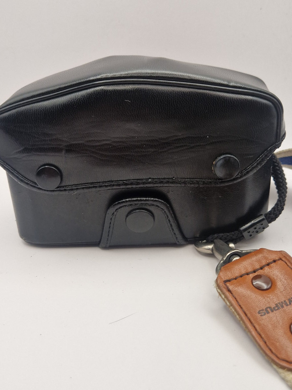 Original Olympus kameraveske – bakside med trykknapper og bærestropp.
