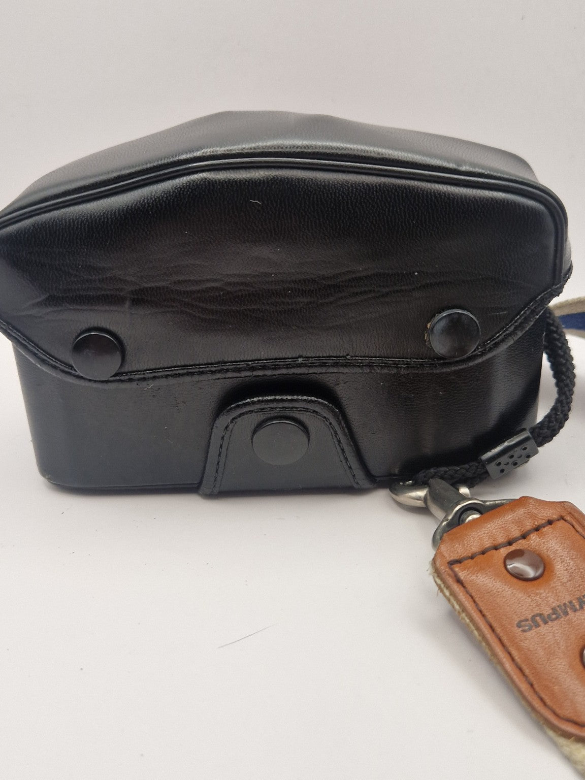 Original Olympus kameraveske – bakside med trykknapper og bærestropp.