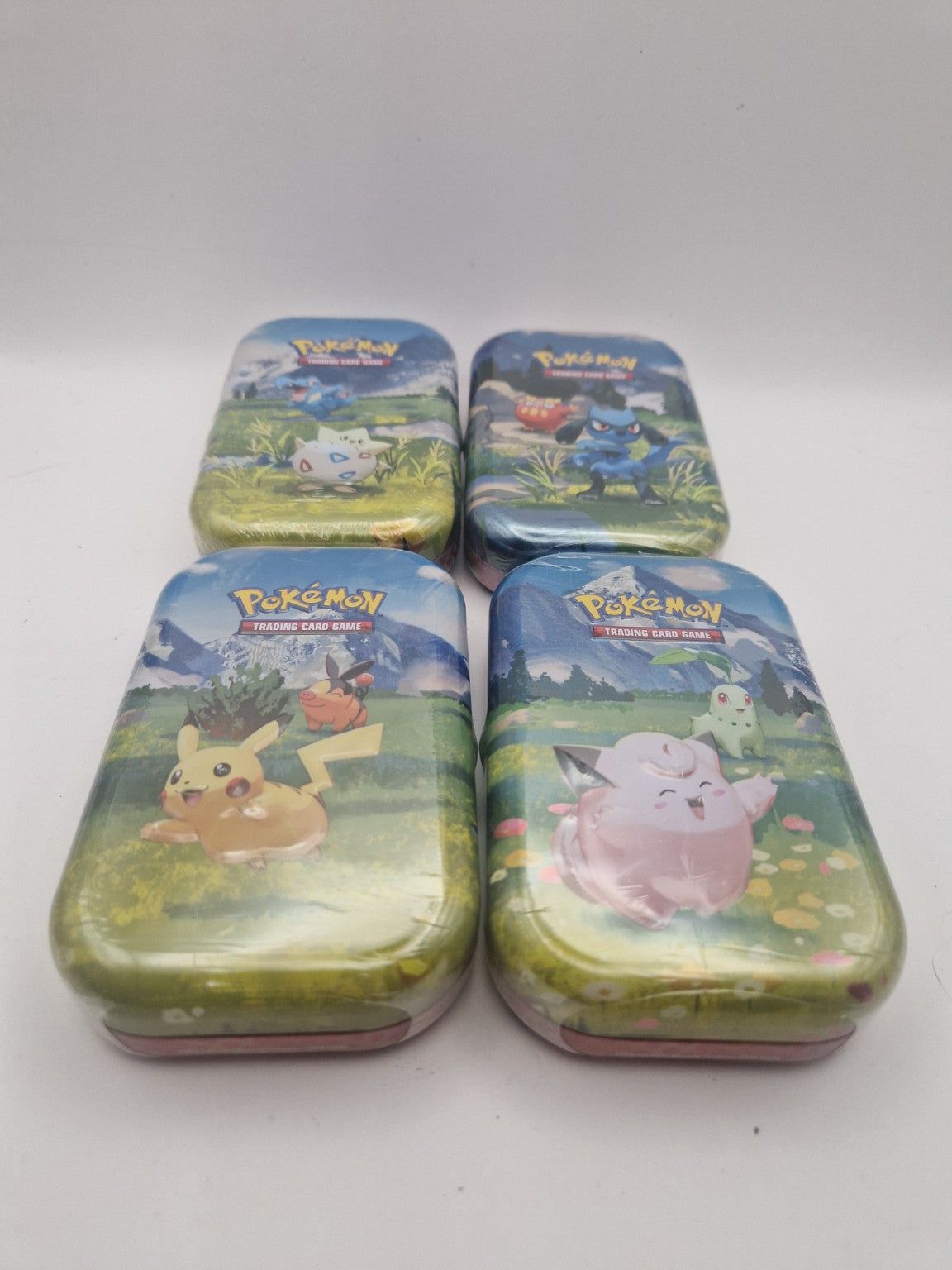 Oversiktsbilde av alle fire Ascended Heroes Mini Tins.