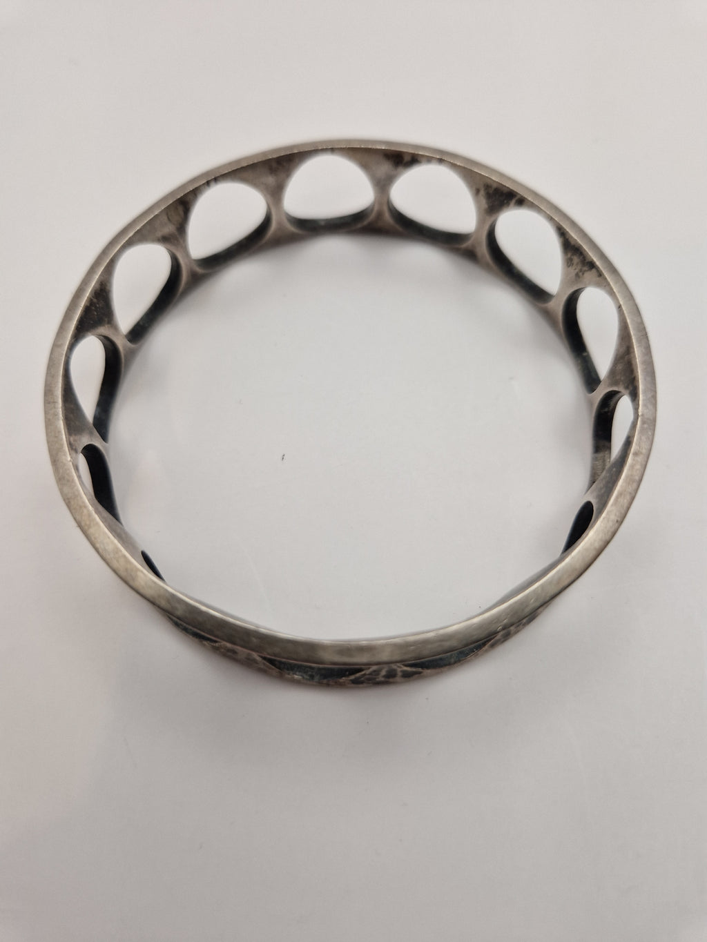 Armringen sett ovenfra – tydelig sirkelform og gjennomgående åpne detaljer.