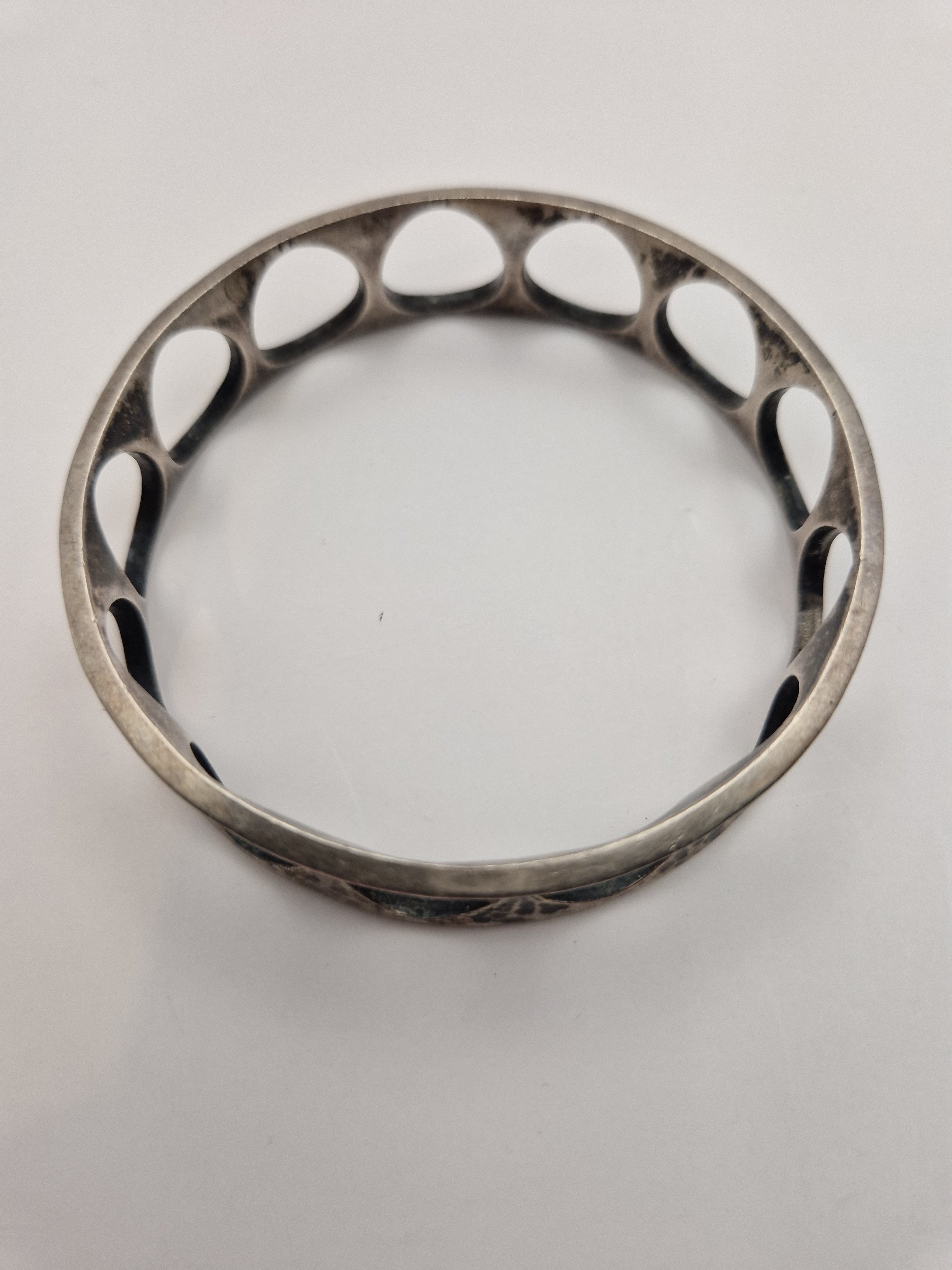 Armringen sett ovenfra – tydelig sirkelform og gjennomgående åpne detaljer.