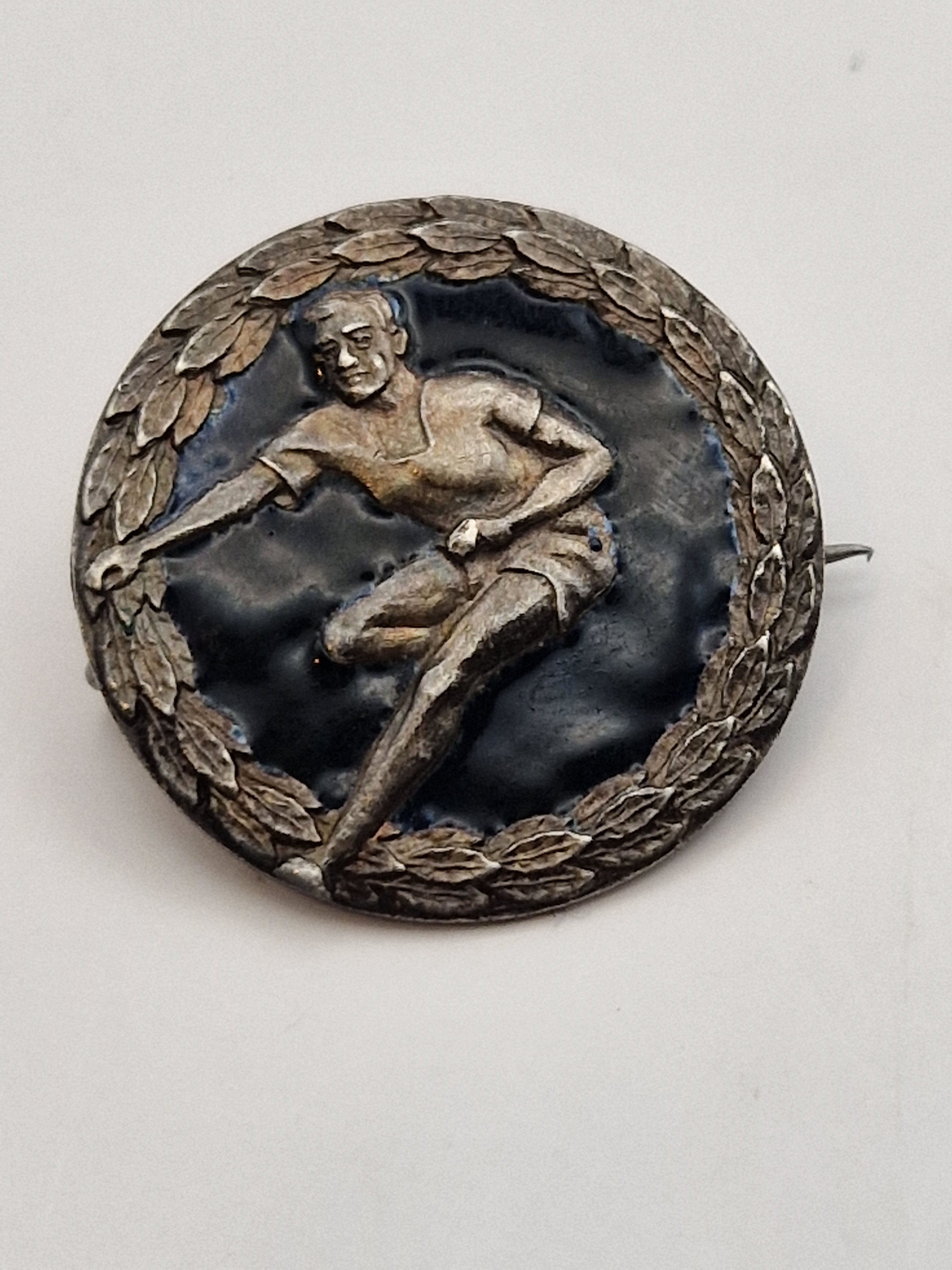 Idrettsmerke i sølv 925 med løpermotiv og laurbærkrans