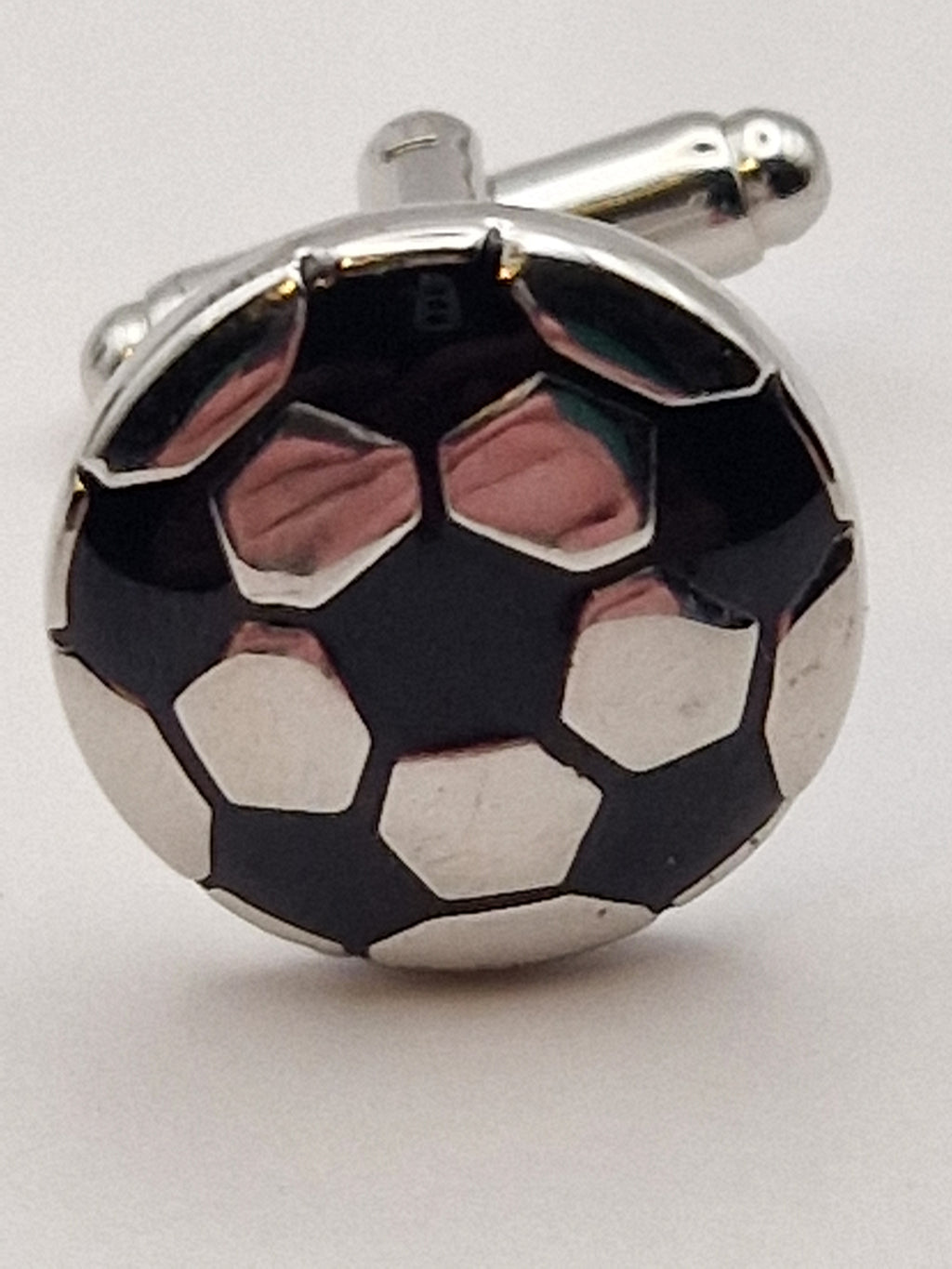 Nærbilde av fotballdesign i sort og hvit emalje