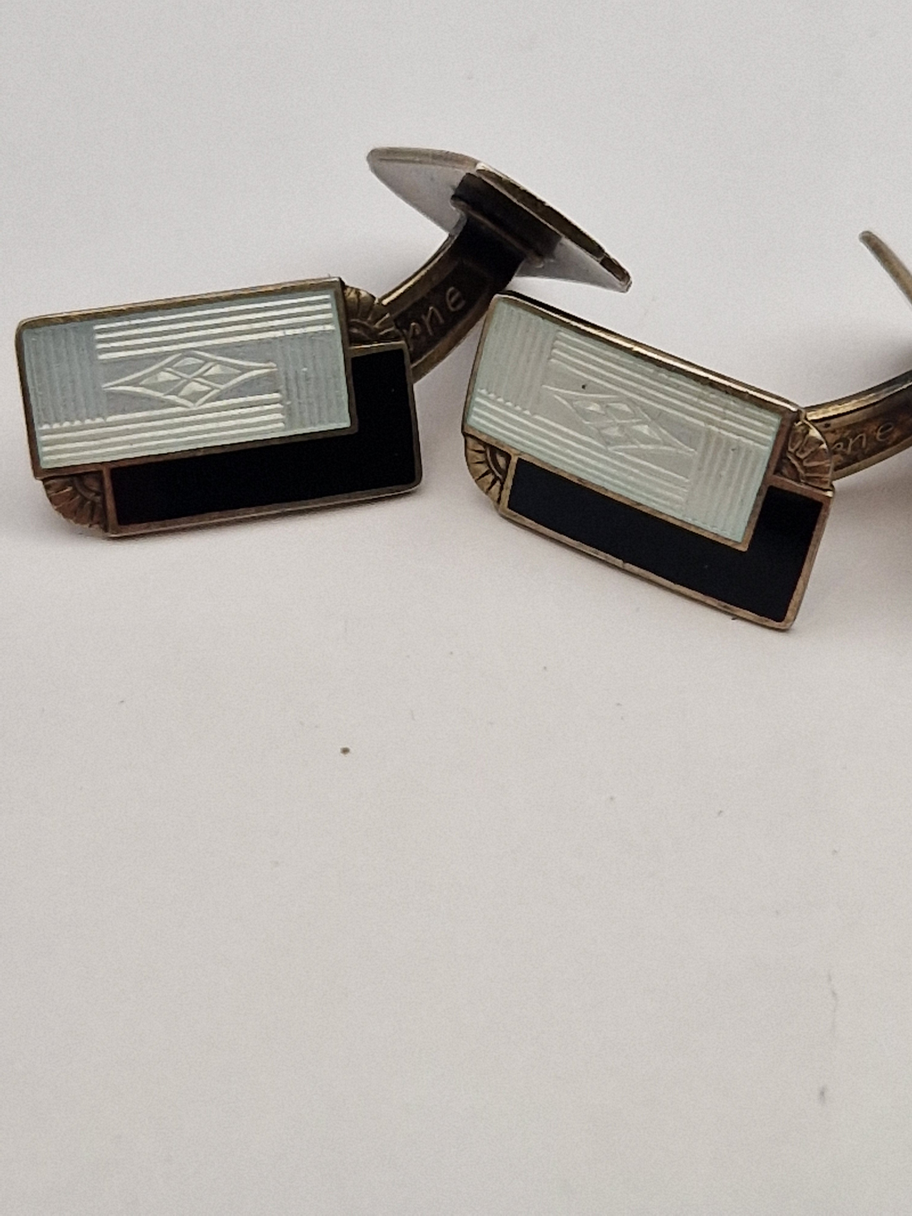 Detalj av mansjettknapper i sterling sølv med emalje