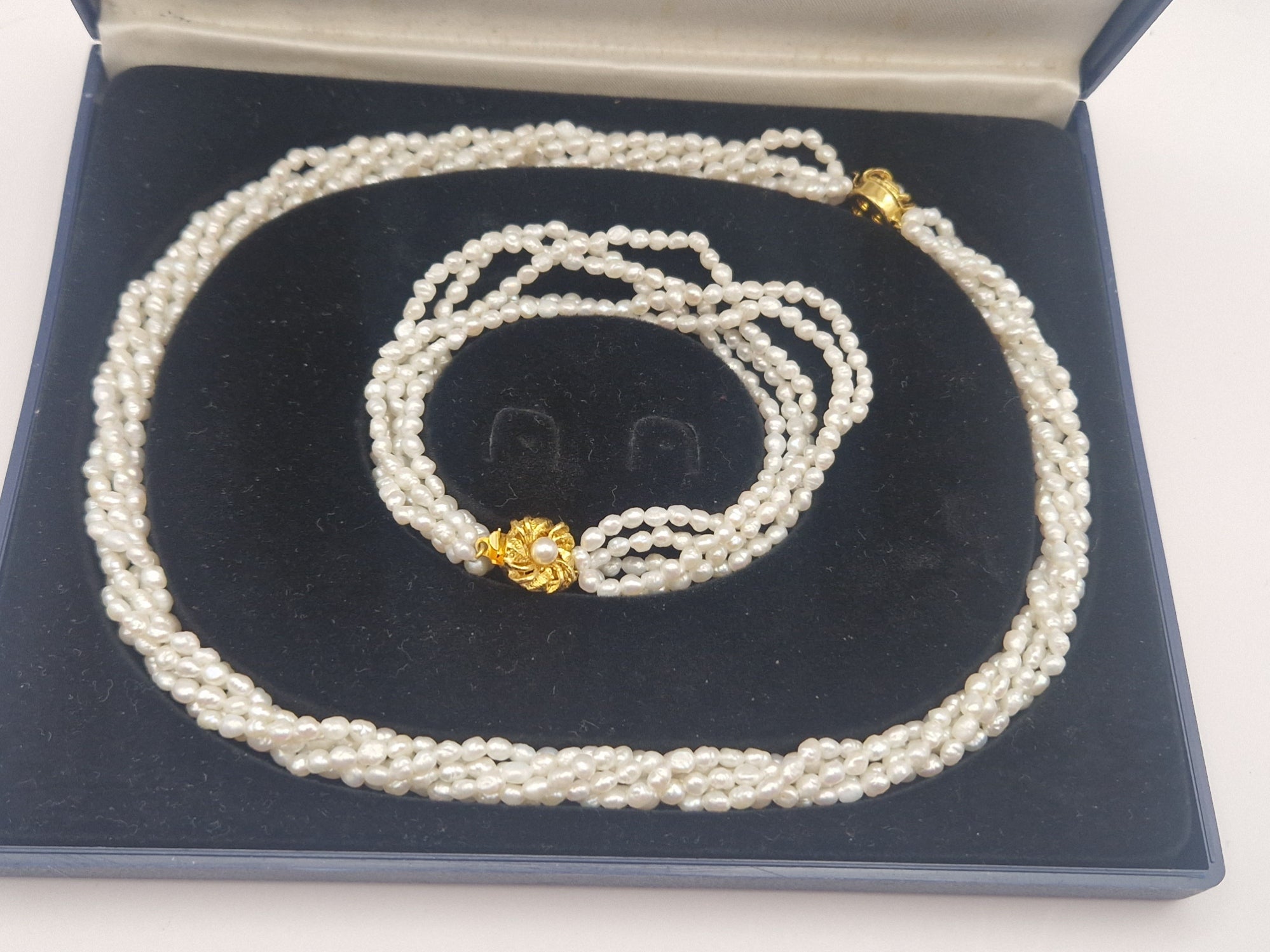 Detalj av ferskvannsperler og forgylt lås