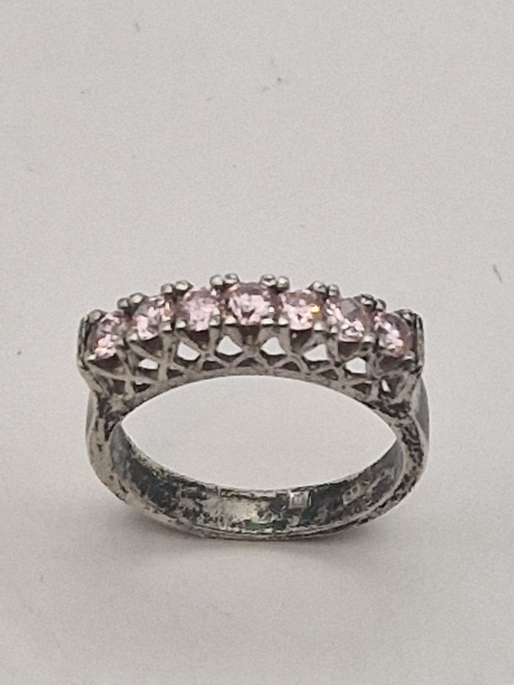 Front av ring med rosa steiner