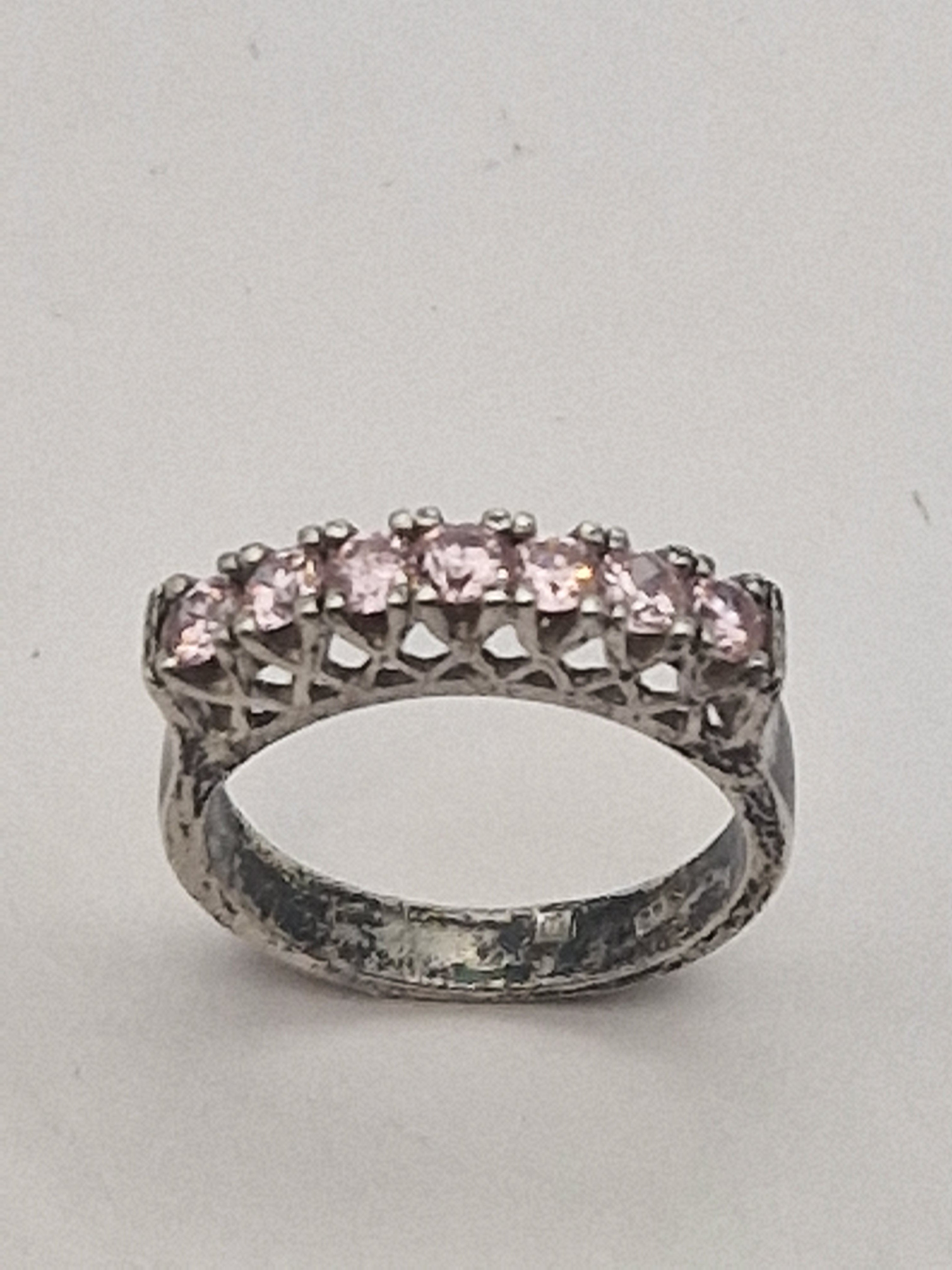 Front av ring med rosa steiner