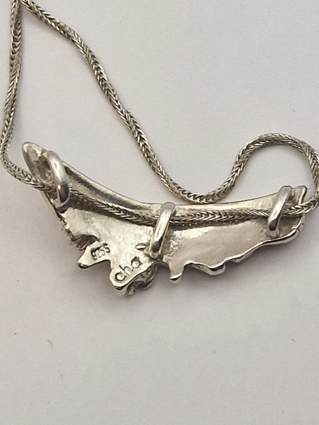 Underside av anheng med mestermerke