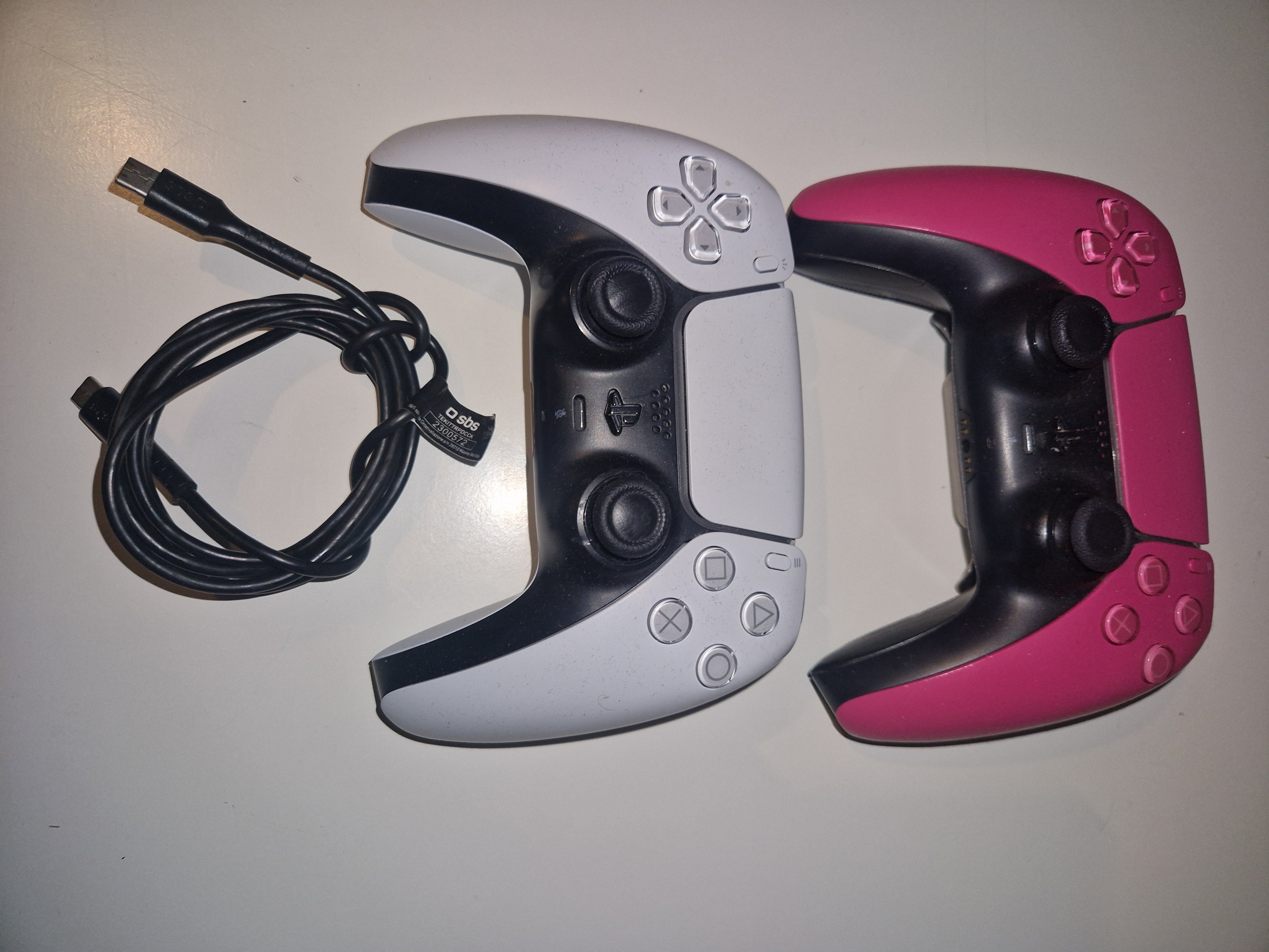 Begge kontrollere + ladekabel